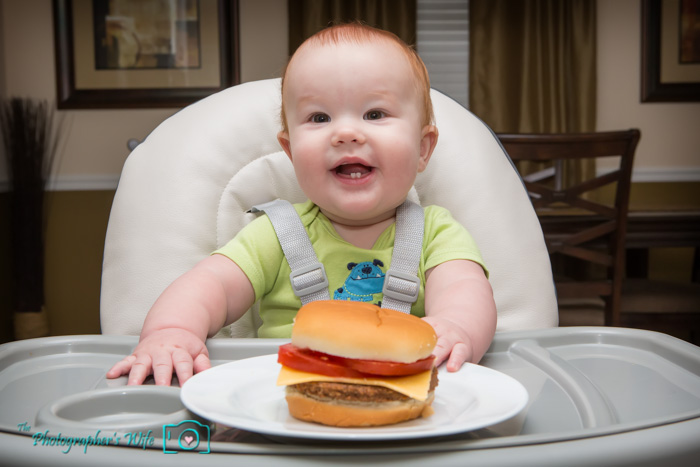 Trent's just playing Vanna White and showcasing the burger...no eating!